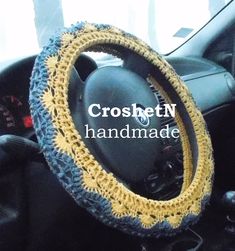 the steering wheel cover is crocheted with yellow and blue yarn, which makes it look like an old car