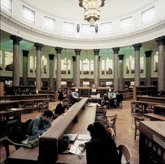 several people are sitting at desks in a library