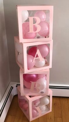 pink and white balloons are stacked on top of each other in the shape of letters