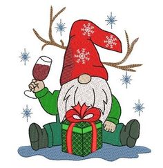 a gnome with a glass of wine sitting on the ground next to a christmas present