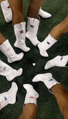 several women's white boots with stars on them are arranged in the middle of a circle