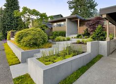 an outdoor garden with concrete planters and grass