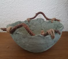 there is a bowl that has been made out of clay and some twigs in it