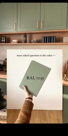 a person holding up a book with the words ral - 793 on it