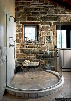 an image of a bathroom with stone walls and flooring on the bottom right side