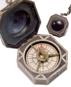 an old fashioned compass and other items on a white background