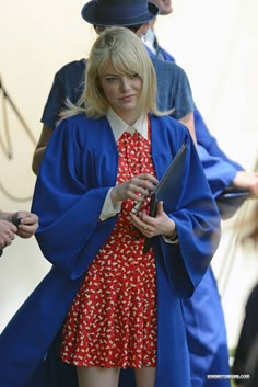 a woman in a red dress and blue coat