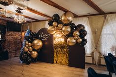 balloons and streamers decorate the entrance to an event with gold, black and silver decorations