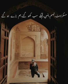 a man standing in front of an arch with writing on the wall above him that reads,