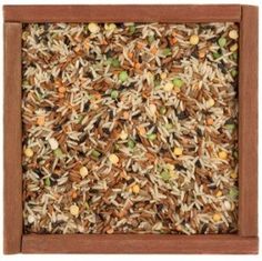 a wooden frame filled with lots of rice and nuts on top of brown grounding