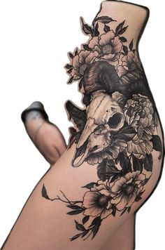 a woman's thigh with flowers and skulls on it, as well as the lower half of her leg