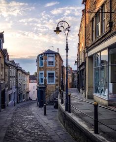 an empty city street with buildings on both sides and a lamp post in the middle