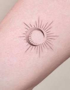 a small sun and moon tattoo on the right arm, which has a black outline