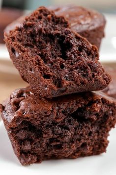 two chocolate muffins stacked on top of each other with one bite taken out