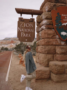 a man standing in front of a sign for the national park