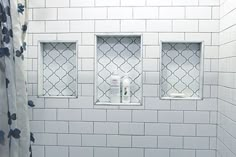 a white tiled bathroom with three windows