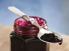 a spoon full of jam on top of a wooden table