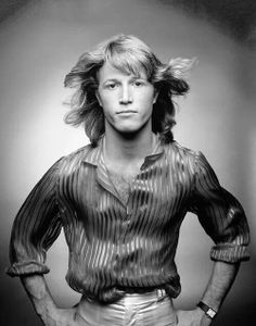 a black and white photo of a man with his hair blowing in the wind,