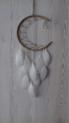 a white dream catcher hanging on a wooden wall