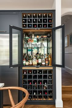 an open wine cabinet with many bottles in it