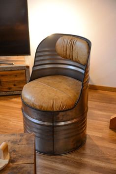 a chair that is sitting in the middle of a room with wood floors and a flat screen tv