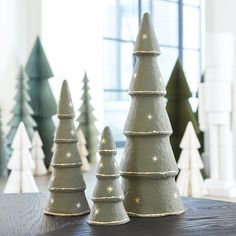 three small christmas trees are on a table