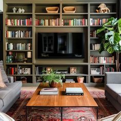 a living room filled with lots of furniture and bookshelves next to a tv