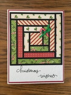 a christmas card with candy canes and holly leaves on it, sitting on a wooden surface