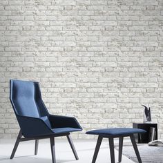 two chairs and a table in front of a brick wall with a tv on it