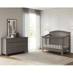 a baby's room with a dresser, bed and crib in grey tones