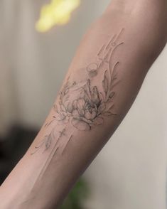 a woman's arm with a flower tattoo on the left side of her arm