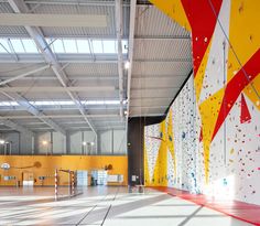 an indoor climbing wall with yellow and red paint