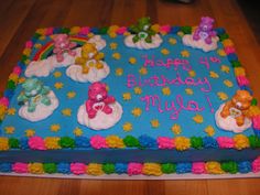 a birthday cake decorated with teddy bears and rainbows