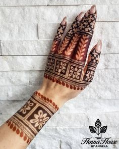 a woman's hand with henna tattoos on it