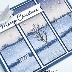 a christmas card with trees and snow in the background, on top of a table