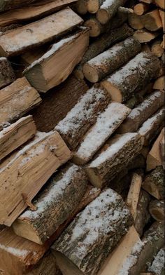 logs stacked on top of each other covered in snow