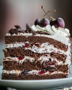 a piece of chocolate cake with white frosting and cherries