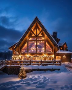 a large wooden house covered in snow and lit up with christmas lights on the windows