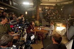 a group of people sitting around a wooden table in front of a camera set up