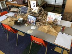 the table is set up with many items on it and there are several chairs around it