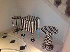 two black and white tables sitting next to each other on top of a tiled floor