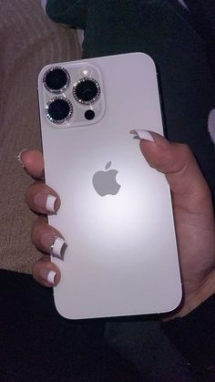 a woman holding an iphone in her hand with the back cover open and two buttons on it