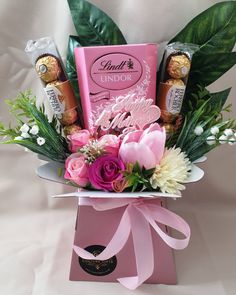 a pink box filled with chocolates and flowers