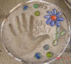 a child's hand and flower made out of sand