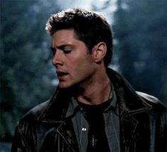 a man in a leather jacket looking down