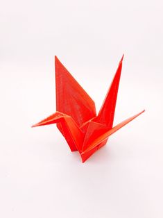 an orange origami bird on a white background