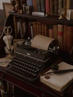 an old fashioned typewriter sitting on top of a desk next to books and other items