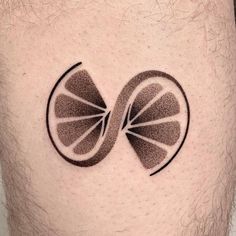 a man's stomach with a tattoo design on the side of his body that has a slice of orange in it