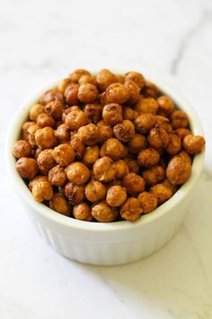 a white bowl filled with nuts on top of a table