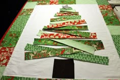 a christmas tree made out of green and red fabric on top of a white table